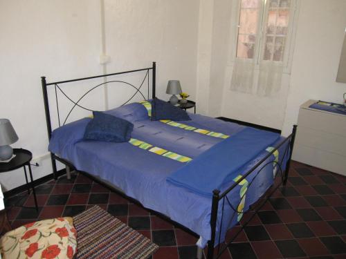 a bedroom with a bed with blue sheets and blue pillows at CASA ROSSA in Borgomaro
