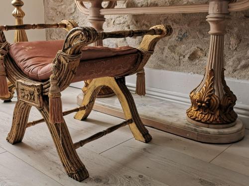 an old wooden chair with a red leather seat at Château de Verdalle in Verdalle