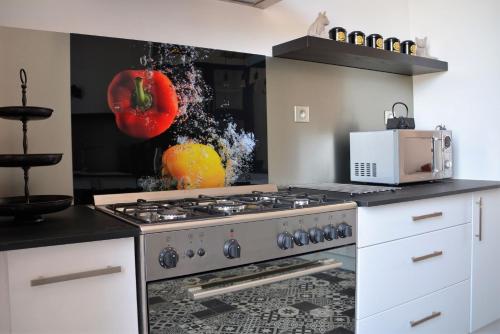 a kitchen with a stove and a microwave at Chez Monsieur le directeur de la poste in Piégut-Pluviers