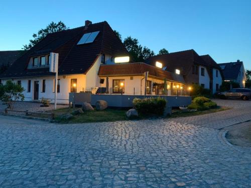 a house on a cobblestone street at night at Ostwind - ferienwohnungen & meer in Steffenshagen