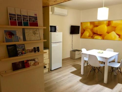 a dining room with a table and a painting of fruit at DÚPLEX Acollidor al Centre de Vic APTGARBI in Vic