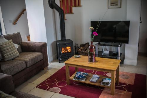 a living room with a couch and a fireplace at Bayview Farm Holiday Cottages in Bushmills