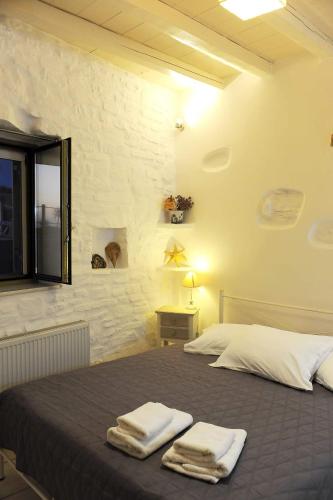 una camera da letto con un letto con due asciugamani sopra di Paros Sunset Villas PSV & PSV2 a Paroikia