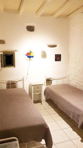 una camera con 2 letti, un tavolo e una TV di Paros Sunset Villas PSV & PSV2 a Paroikia