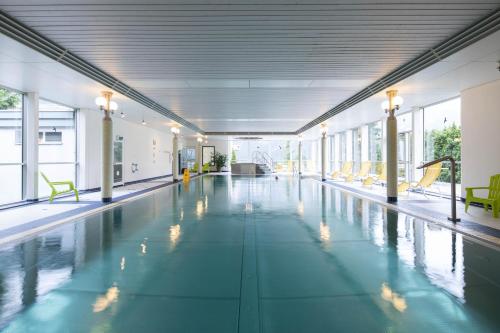 an empty swimming pool with chairs in a building at Parkhotel Schoenegg in Grindelwald