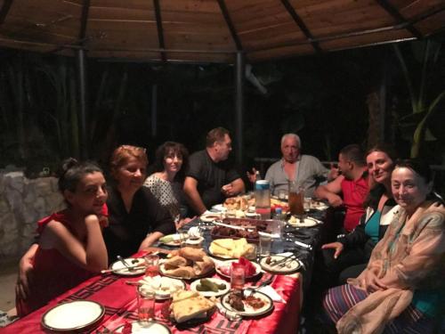 a group of people sitting around a table with food at Iberia 2019 in Batumi
