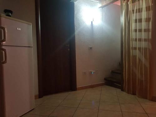 a kitchen with a refrigerator and a tile floor at Casa vacanza Gigi e Antonella in Porto Rotondo
