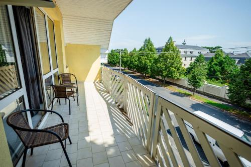 a balcony with chairs and a view of a building at Teraszos vendégház in Keszthely