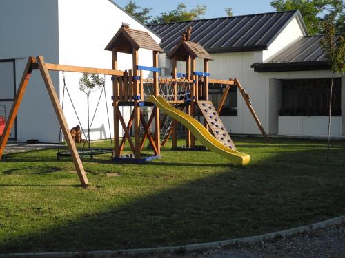 un parque infantil con un tobogán en un patio en Kerámia - Vendégszobák en Szekszárd