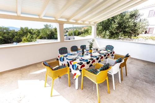 - une table et des chaises sur une terrasse couverte dans l'établissement Villa Decima, à Milna