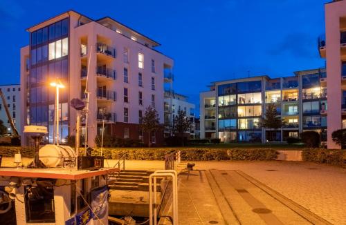 a group of buildings in a city at night at "myHarbourfront", luxuriöses Wohnen an der Hafenmole in Rostock
