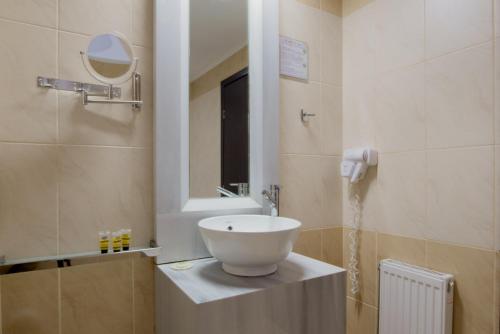 a bathroom with a white sink and a mirror at Aar Hotel & Spa Ioannina in Ioannina