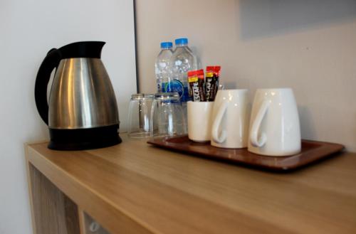 a counter with a coffee pot and mugs on it at V One Pride-Sukhumvit 22, Bangkok in Bangkok