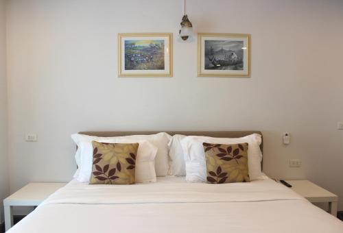 a bedroom with a bed with two pictures on the wall at V One Pride-Sukhumvit 22, Bangkok in Bangkok