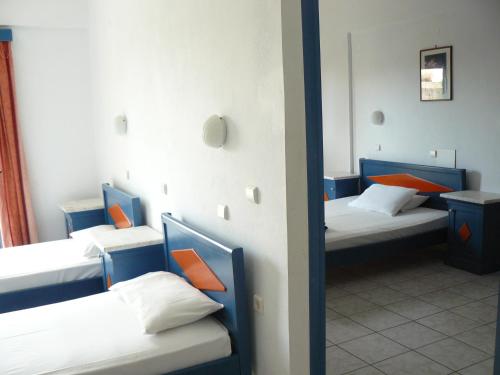 a room with two beds with orange pillows at Leonidas Studios & Apartments in Georgioupolis