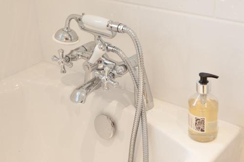 a bathroom sink with a faucet and a bottle of soap at The Cavendish Arms in Cartmel