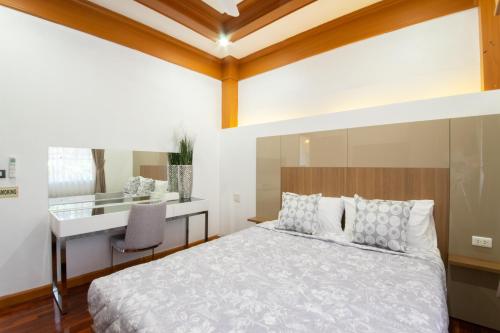 una camera con letto e scrivania di Rudi House a Patong Beach