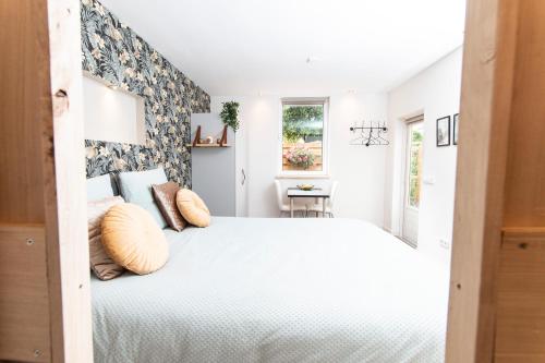 1 dormitorio con 1 cama blanca grande con almohadas en Eindhoven Inn, en Eindhoven