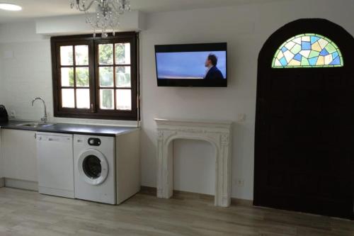 a room with a washing machine and a tv on the wall at Marinela in Hendaye
