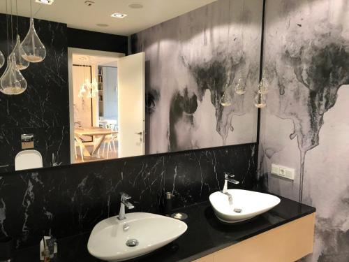 a bathroom with two sinks and a large mirror at Vantage Point Apartament Sky Tower in Wrocław