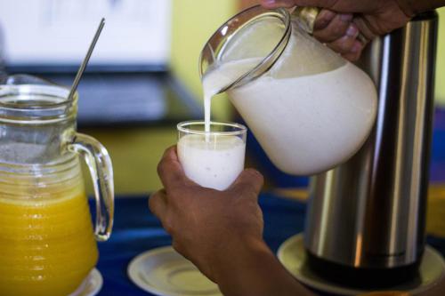 a person is pouring milk into a blender at Pousada Rota das Águas in Nobres