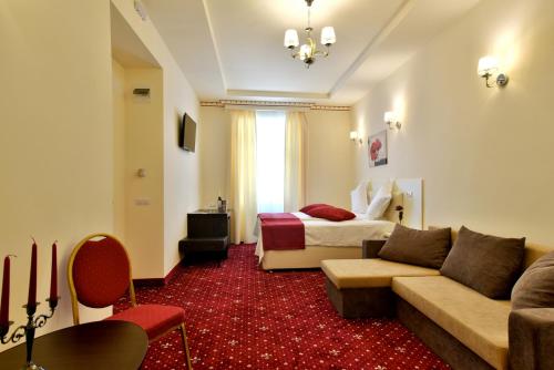 a hotel room with a bed and a couch at Top Royal Central Brasov in Braşov