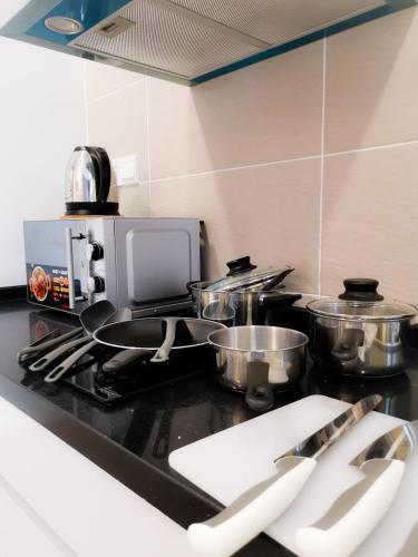 a kitchen counter with pots and pans on a stove at Legoland D'PRISTINE Apartment By TGP in Nusajaya