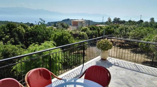 a balcony with chairs and a vase on it at Country Side House (View, Parking, wifi, Fenced Yard, Close to the Sea) in Koroni