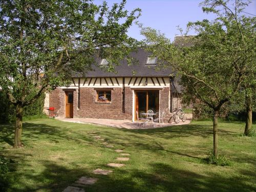 a brick house with a window and a bike in a yard at Gîte du Valcrocq 4/5 pers in Le Bec-Thomas