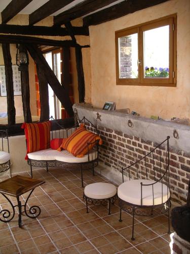 a room with two chairs and tables and windows at Gîte du Valcrocq 4/5 pers in Le Bec-Thomas