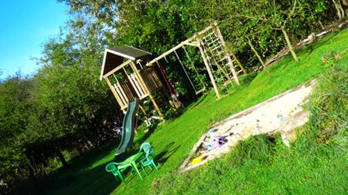 a park with a playground with a slide and a slideintend at Gîte du Valcrocq 4/5 pers in Le Bec-Thomas