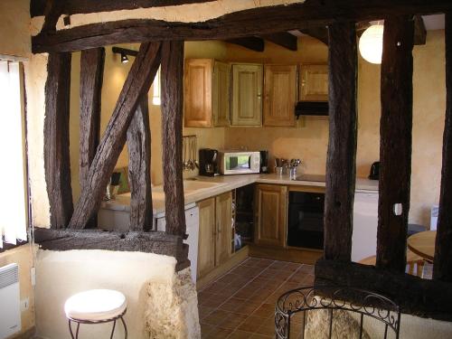 a kitchen with wooden cabinets and a table and chairs at Gîte du Valcrocq 4/5 pers in Le Bec-Thomas