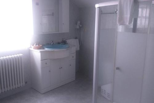 a white bathroom with a sink and a shower at Apartamento Planeta 2º centro in O Porto de Espasante
