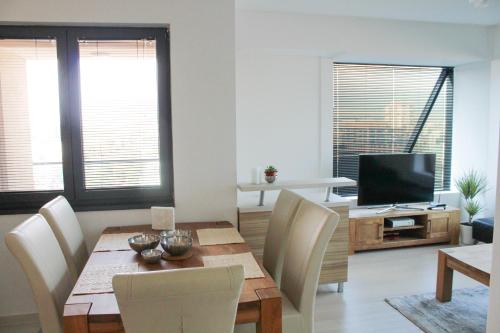 a dining room with a table and a television at High End Apartments in Diamond Garden Building in Skopje