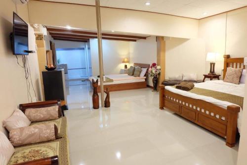 a large room with two beds and a couch at Binlar Guesthouse in Phra Nakhon Si Ayutthaya