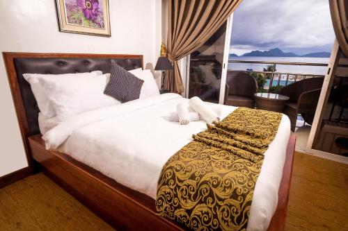 1 dormitorio con 1 cama y vistas a un balcón en El Nido Royal Palm Inn, en El Nido