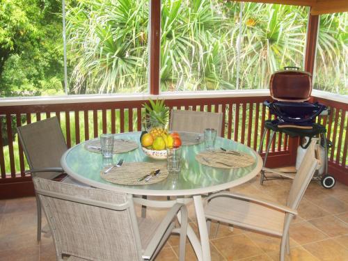 a table with a bowl of fruit on a porch at River Estate Riverhouse in Hanalei