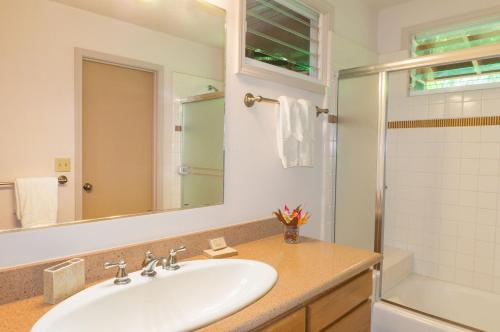 a white bathroom with a sink and a shower at River Estate Riverhouse in Hanalei