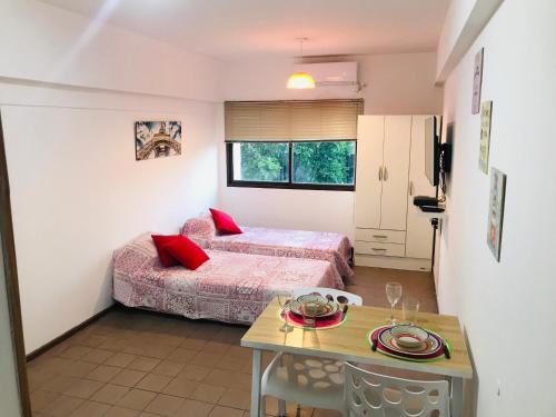a small bedroom with two beds and a table at Departamento Temporario Céntrico Mendoza in Mendoza