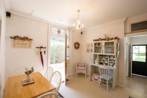 comedor con mesa, sillas y TV en Jasmine's Barossa Valley Cottage, en Lyndoch