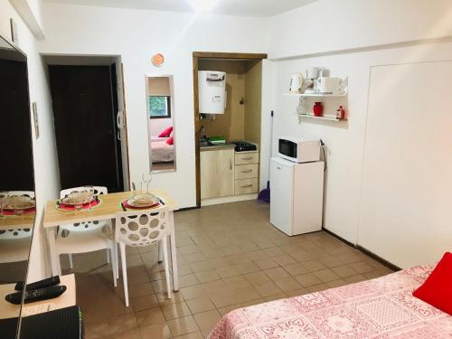 a small kitchen with a table and a refrigerator at Departamento Temporario Céntrico Mendoza in Mendoza
