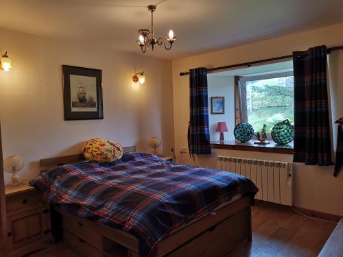 a bedroom with a bed and a window at Berneray Otter Cottage in Berneray