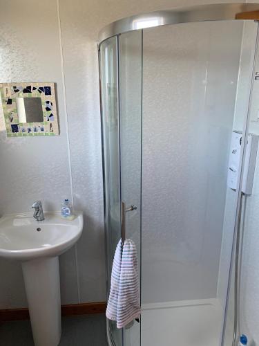 a bathroom with a shower and a sink at Berneray Otter Cottage in Berneray