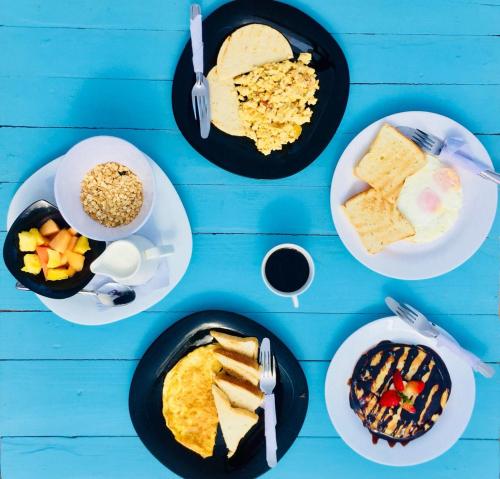 una mesa azul con platos de desayuno en Playa del Ritmo Beach Hostel & Bar - Adults Only, en Santa Marta