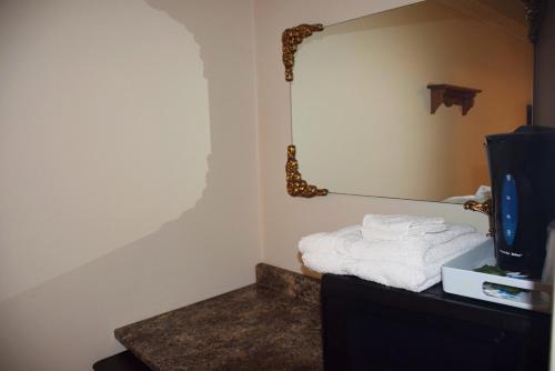 a room with a mirror and a bed with towels at Kent Motel in Chatham