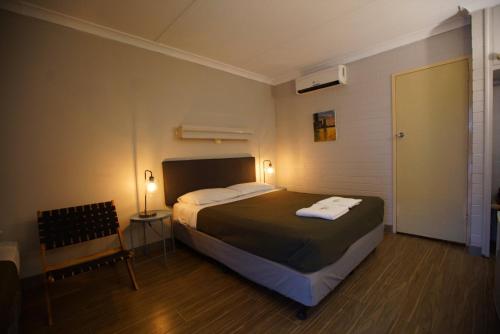 1 dormitorio con 1 cama con 2 toallas en Motel Maroondah, en Box Hill