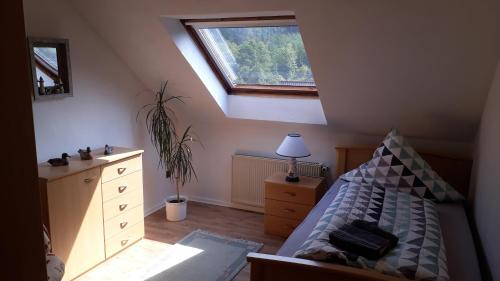 - une chambre mansardée avec un lit et une fenêtre dans l'établissement Ferienwohnung Deichsel, à Sundern
