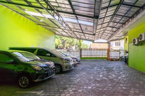 a garage with several cars parked in it at RedDoorz near Kejaksan Station Cirebon 2 in Cirebon
