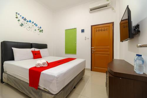 a bedroom with a bed and a television in it at RedDoorz near Kejaksan Station Cirebon 2 in Cirebon