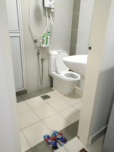 a bathroom with a toilet and a sink at Ayu Homestay DPerdana Apartment in Kota Bharu